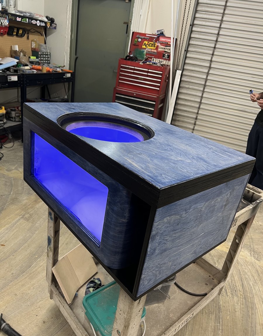 Custom subwoofer box with a blue LED glow around the sub cutout