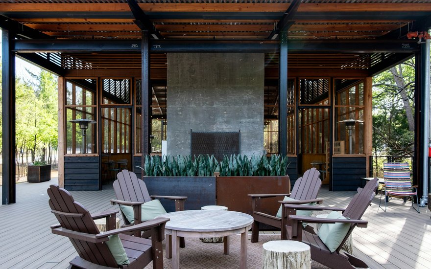 A finished concrete patio behind a home with a pergola and outdoor seating