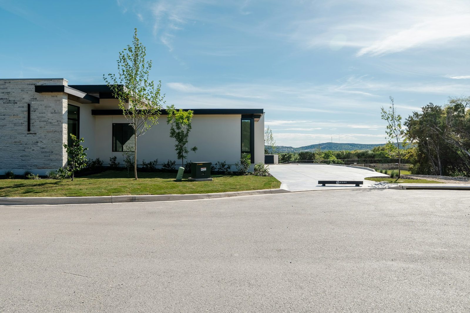 Wide new concrete driveway and apron sweeping up to a modern single-storey home