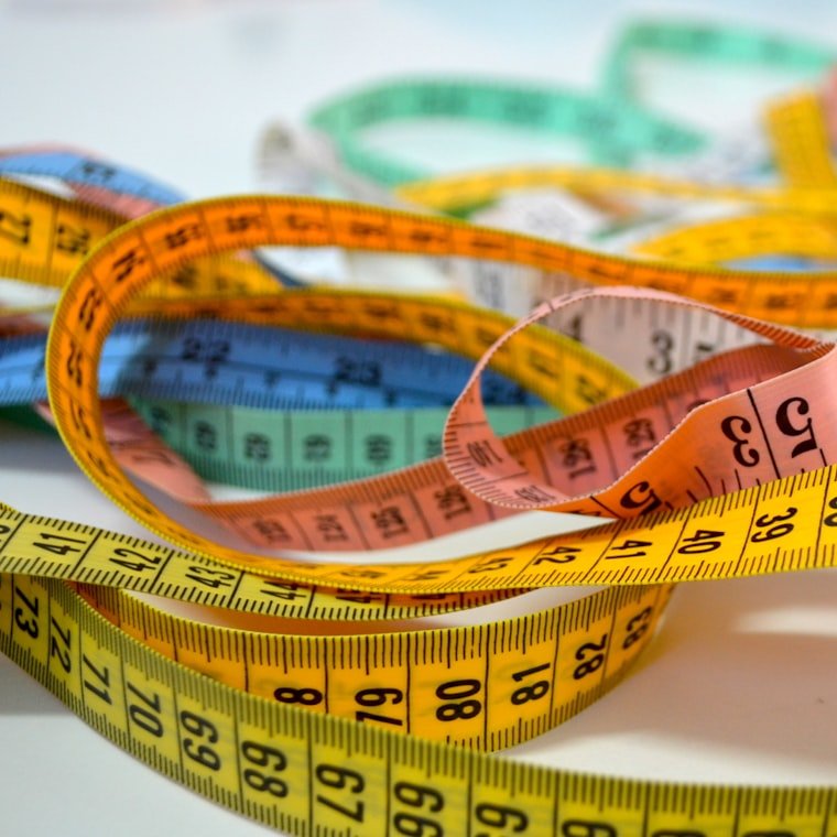 A tailor's tape measure coiled on the workbench
