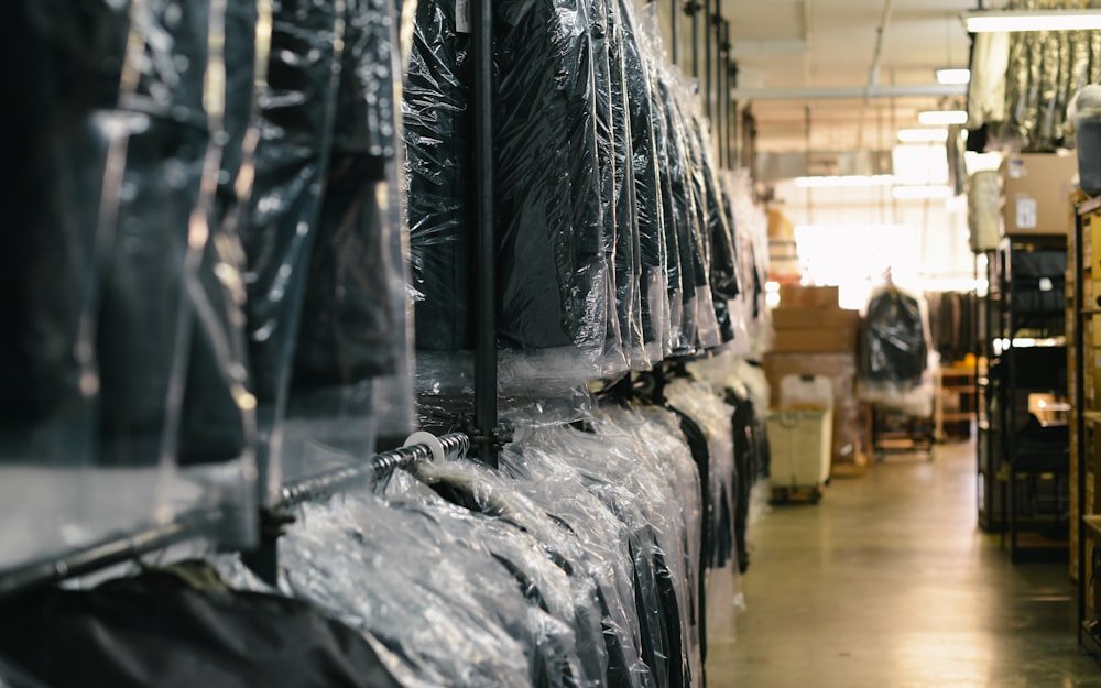 Row of freshly dry-cleaned shirts in protective garment bags on a rack