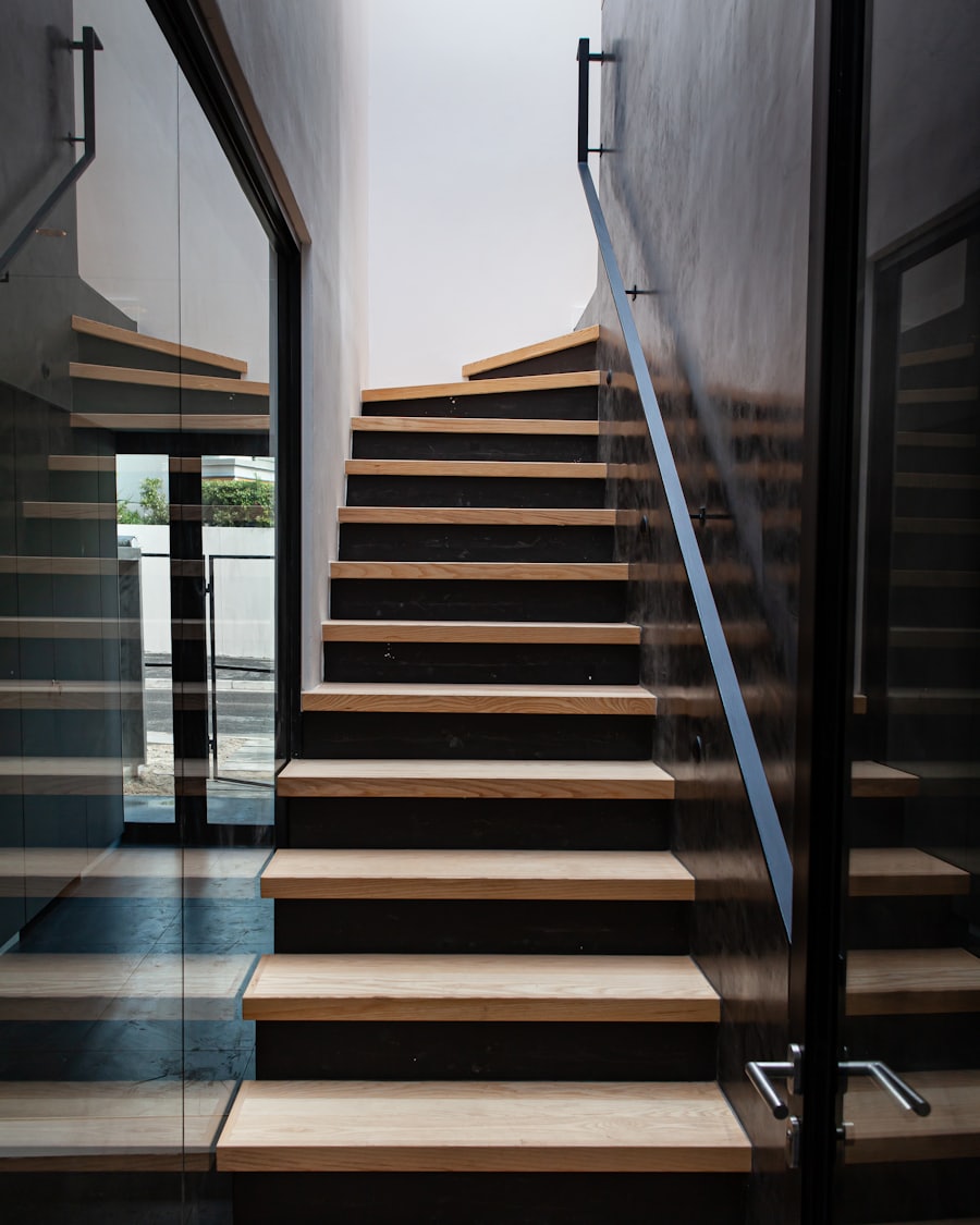 Light oak stair treads set against dark risers in a modern stairwell with a glass railing