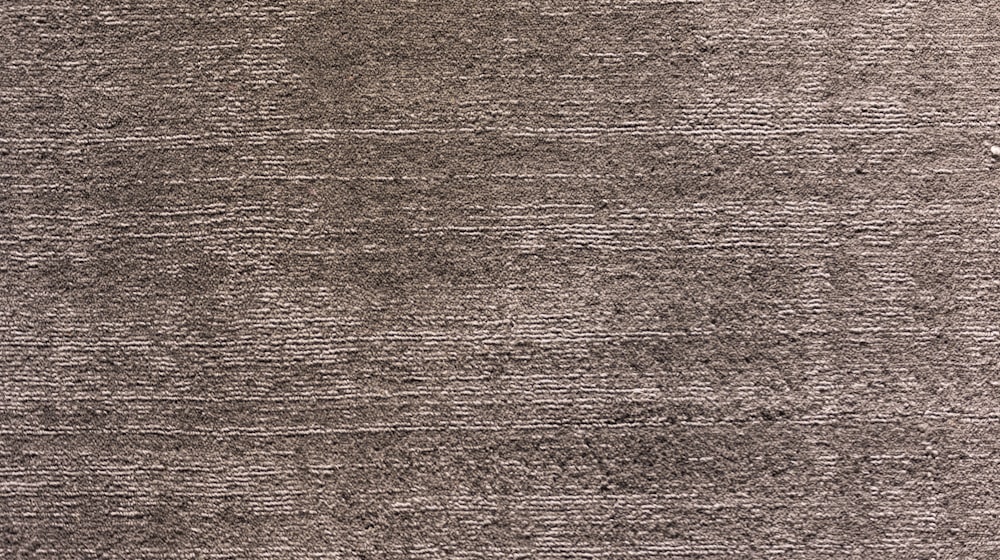 Close-up of soft taupe carpet pile laid tight and even across a floor