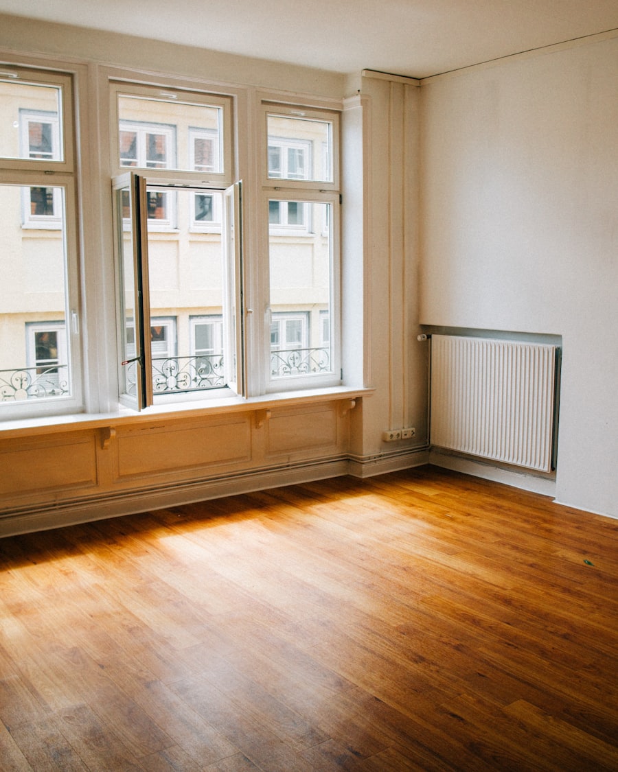 Warm oak-toned wood plank flooring running through a bright, freshly finished room with tall windows