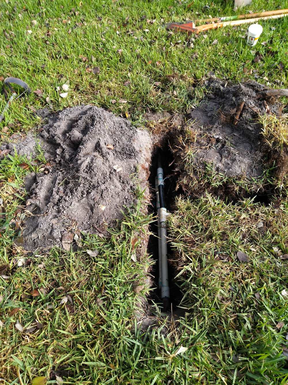 Sod carefully cut back to expose and repair an underground irrigation line