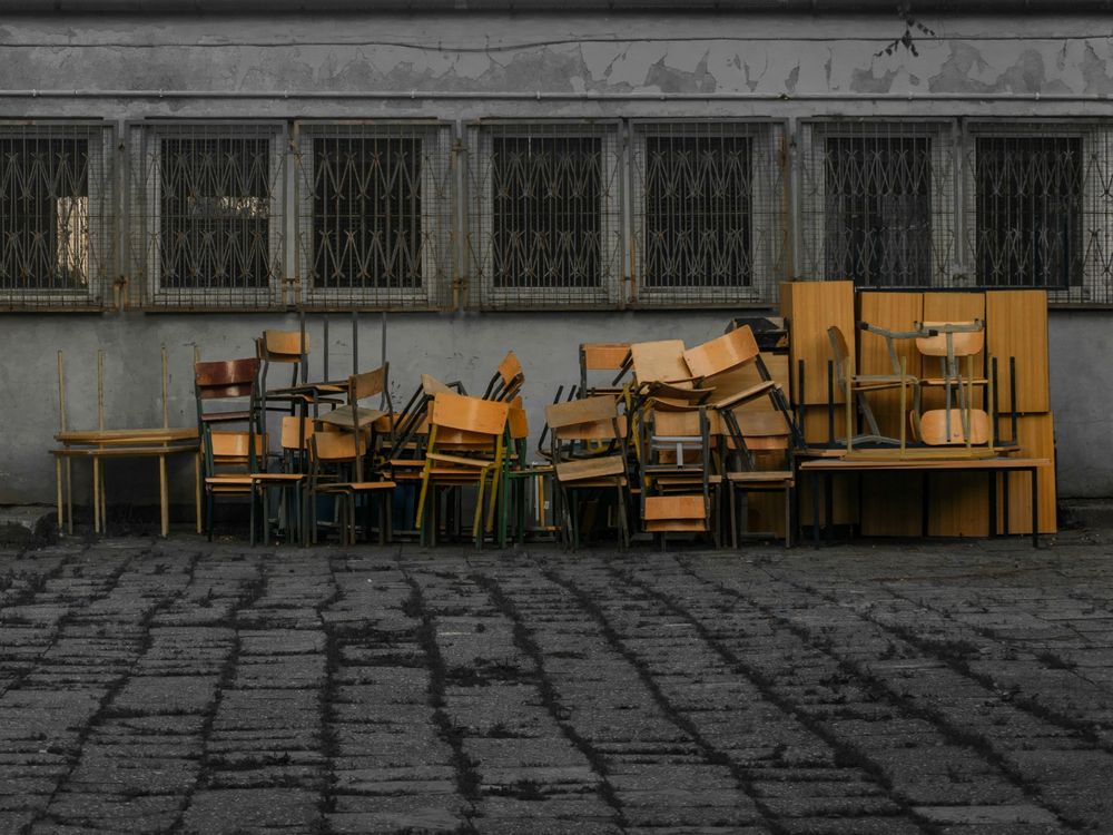 A stack of old chairs and tables set out for furniture removal