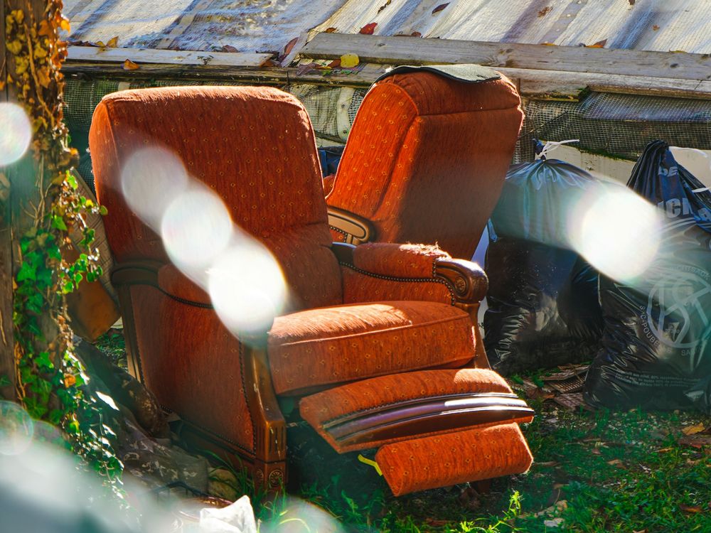 Bulky old upholstered chairs set outside to be hauled away