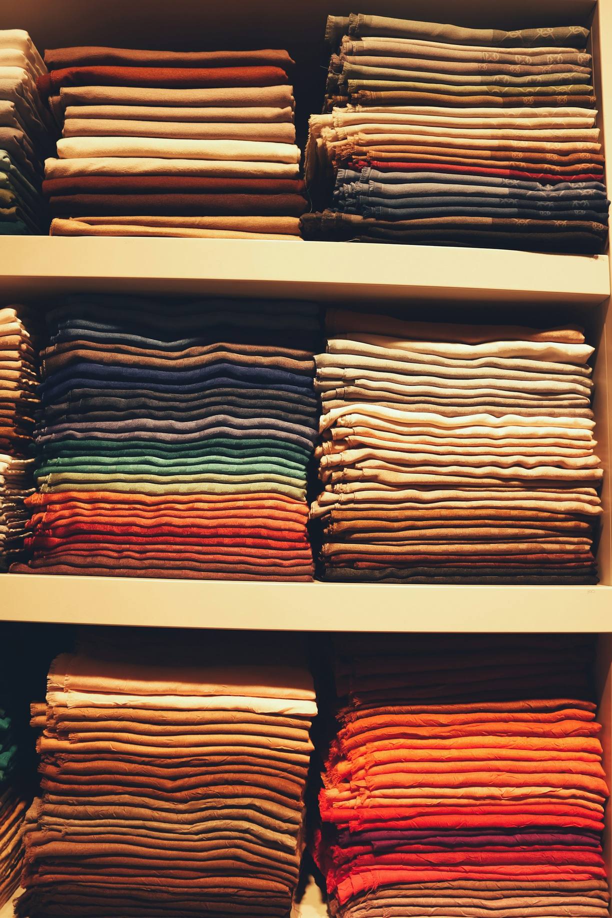 Shelves of neatly folded custom shirts in a range of colors