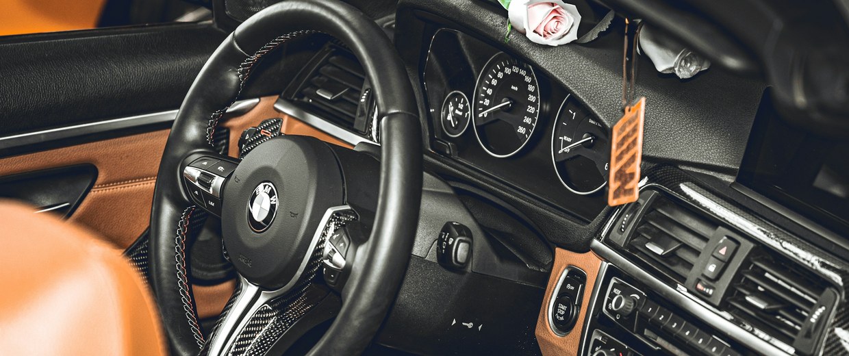 Modern car interior with cognac leather trim and a stitched steering wheel