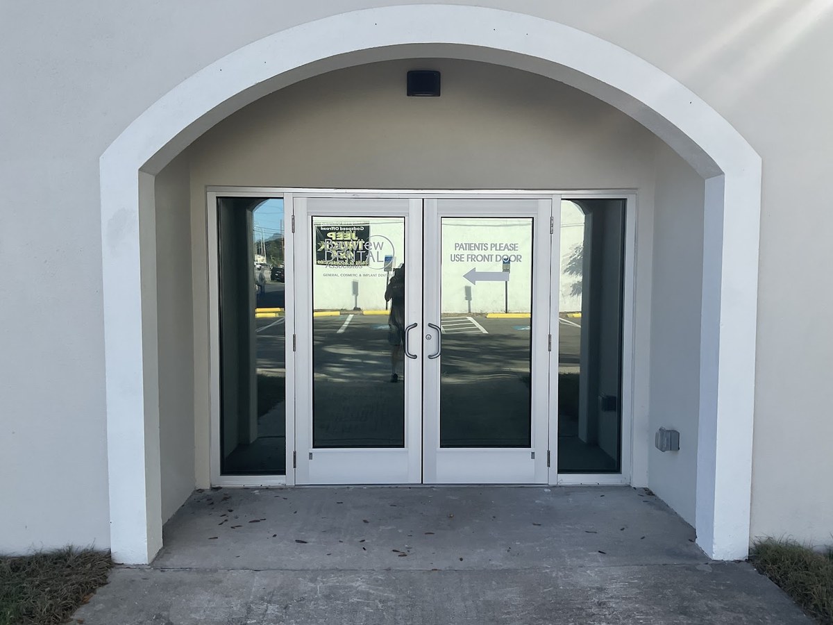 Office building entrance with tinted glass doors and sidelights