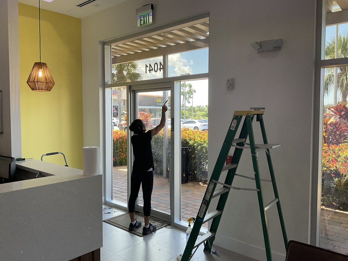 Installer applying window film to a commercial glass entry door